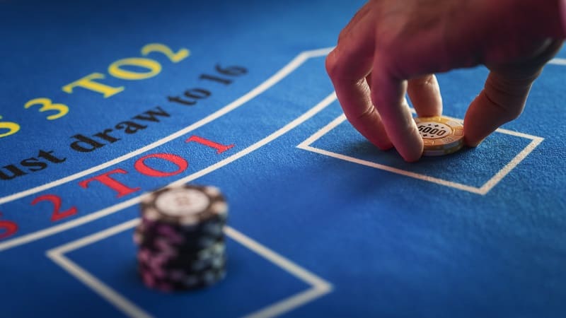 百家樂遊戲桌上，玩家正將籌碼放置於投注區域，背景清楚標示賠率。